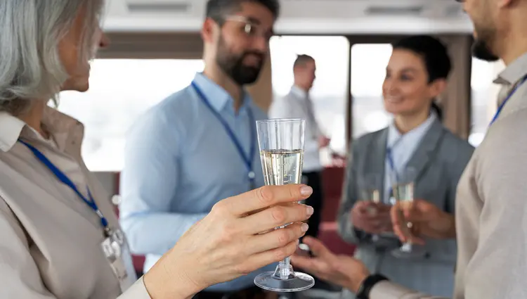 Ejecutivos en una fiesta hablando y bebiendo